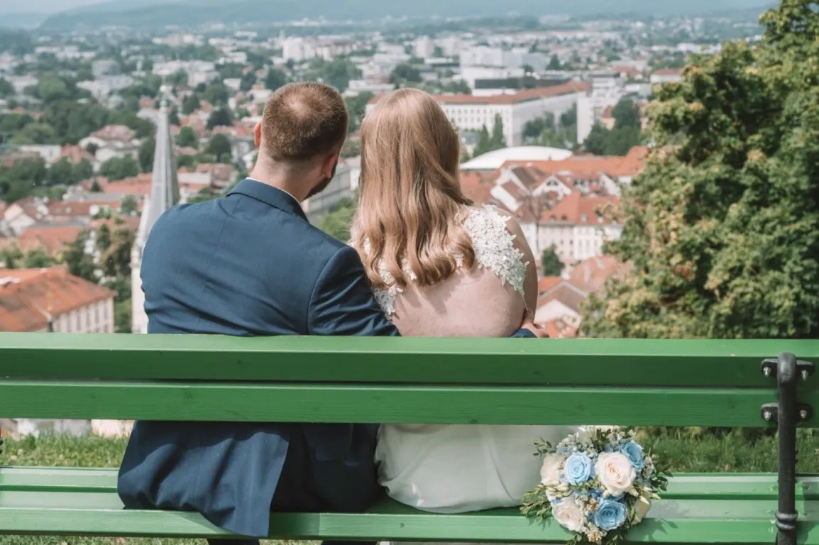 Poročna fotografija mladoporočencev; ujet pristen trenutek z naravno svetlobo in umirjeno kompozicijo v dokumentarnem slogu.